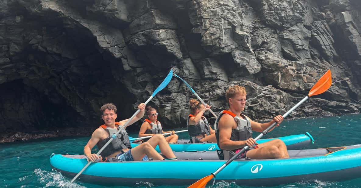 Kayakers paddling beneath the towering Los Gigantes cliffs in Tenerife